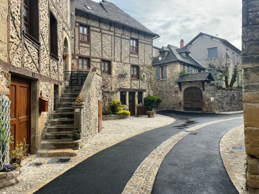 Aménagement de voirie dans le village médiéval de Sainte-Eulalie-d'Olt par AQUI Ingénierie - réfection de chaussée en centre historique aveyronnais